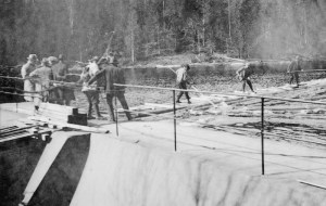 Vanebudammen med tømmerfløtere, bildet tatt ca. 1920. Foto: Siljan Historielag