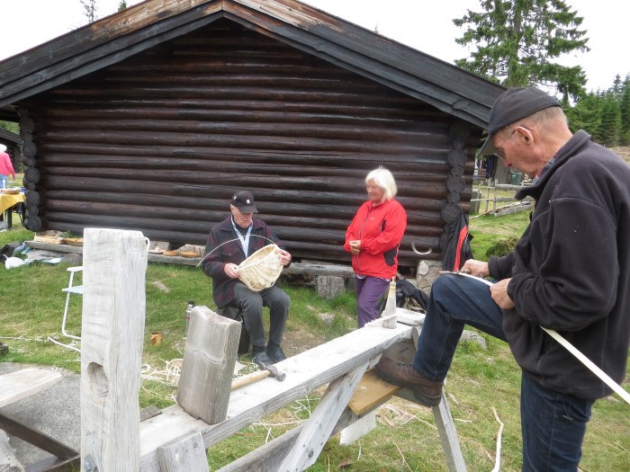 Hans Røsholt og Reidar Røse viser flisefatfletting. Toril Engelbretsen ser på. 21.7.12