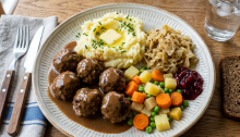Swedish meatballs with mashed potatoes, vegetables, gravy, and lingonberry sauce